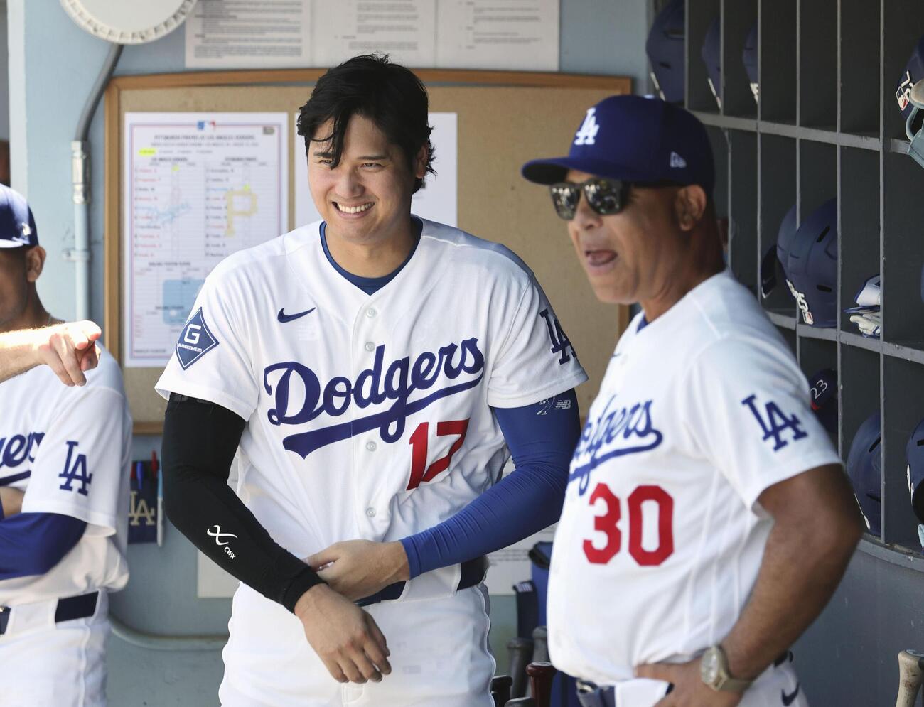 試合前、ベンチで笑顔を見せるドジャース大谷とロバーツ監督（右）（共同）