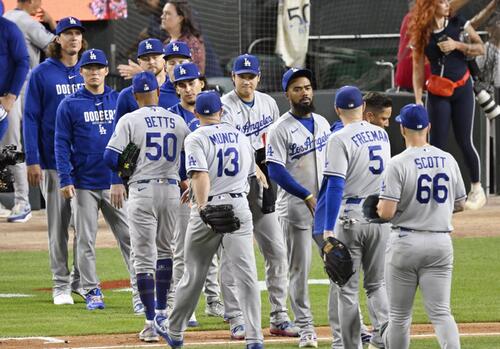 タイガースに勝利し、タッチを交わすドジャース・大谷(中央)。左から2人目は山本=デトロイト(共同)