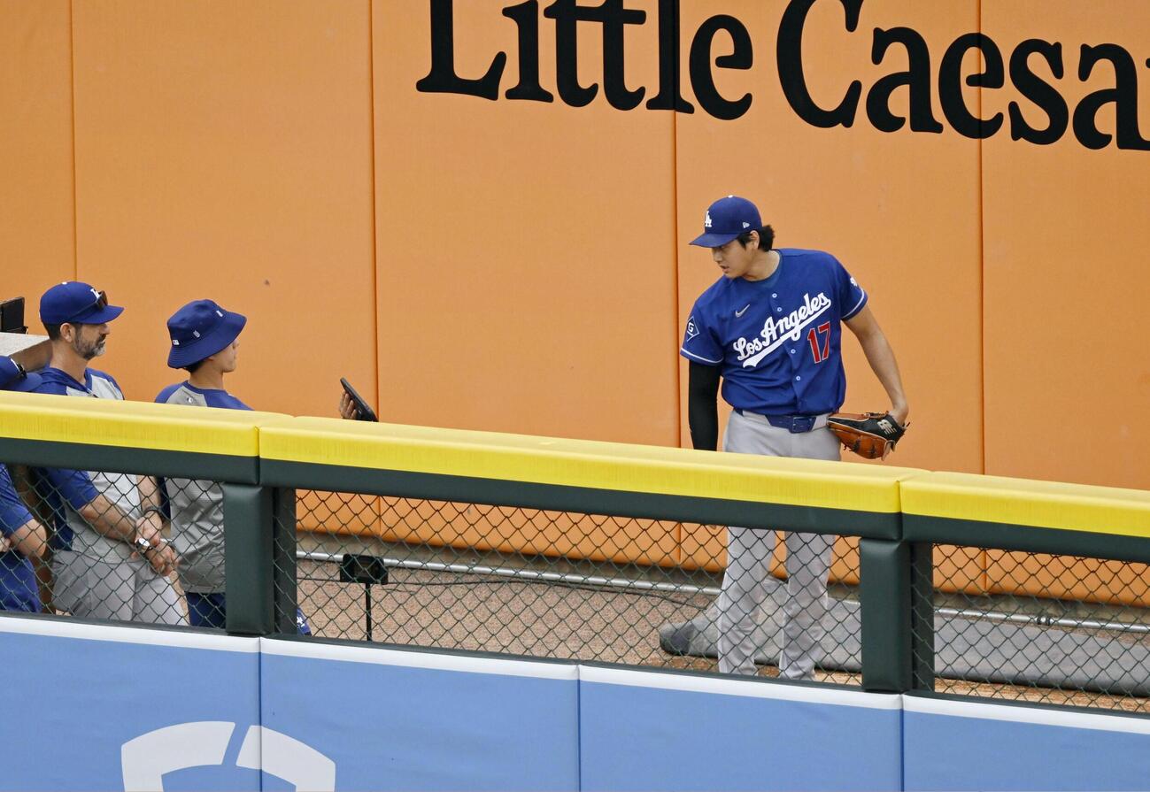 ブルペンでの投球練習でタブレット端末を見るドジャース・大谷＝デトロイト（共同）