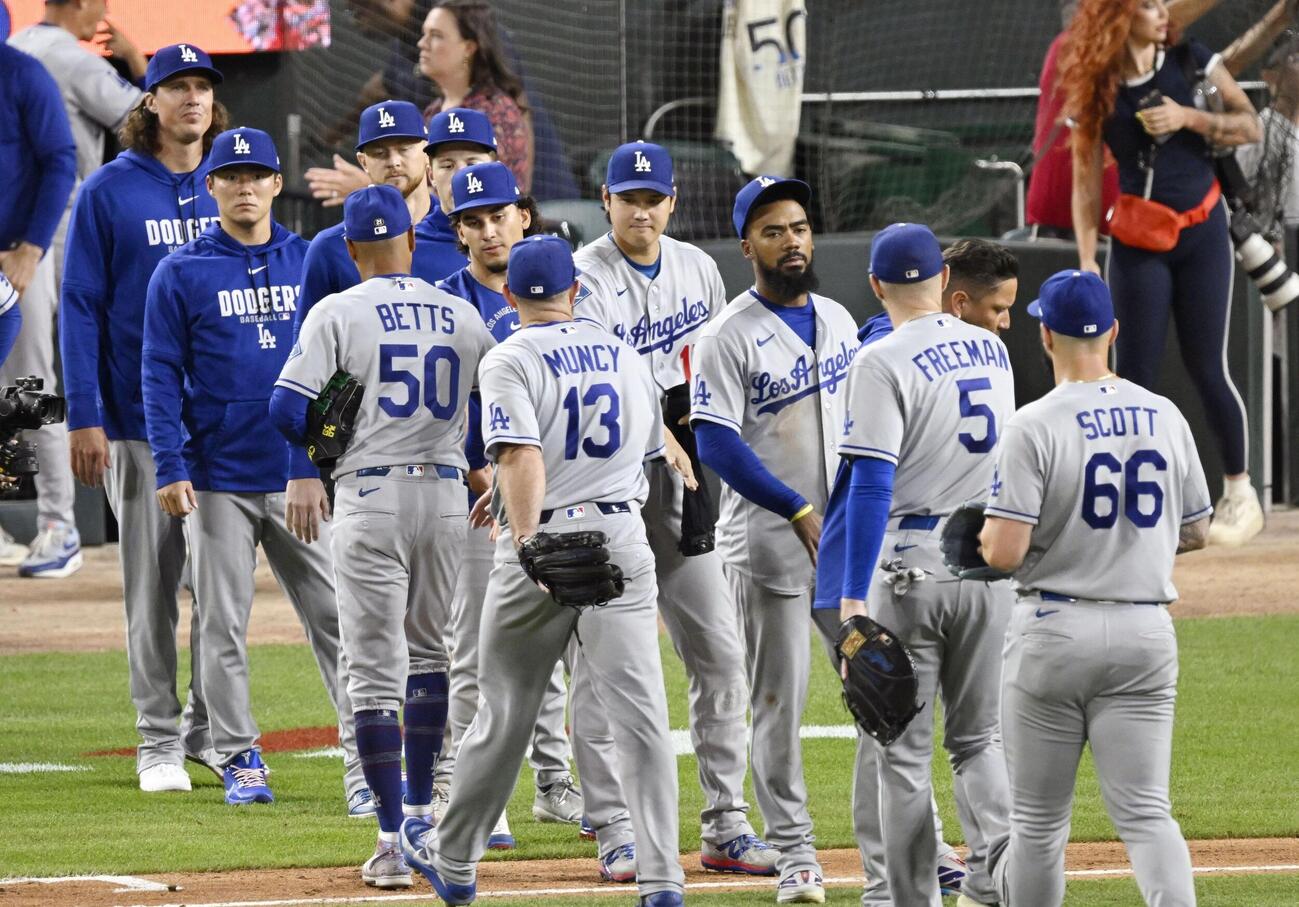 タイガースに勝利し、タッチを交わすドジャース大谷（中央）。左から2人目は山本（共同）
