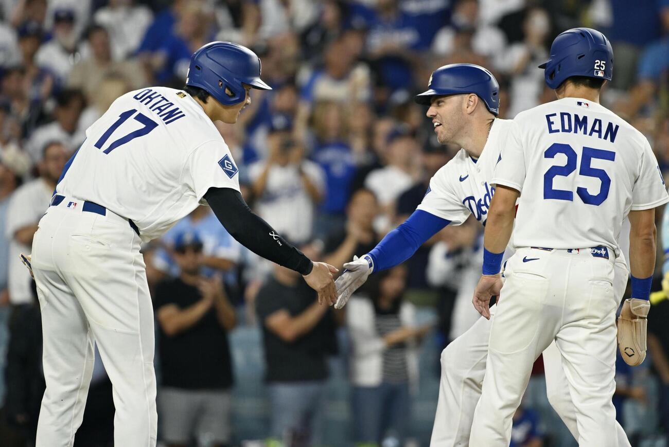 カージナルス戦の1回、先制3ランを放ったフリーマン（中央）とタッチを交わすドジャース・大谷（左）＝ロサンゼルス（共同）