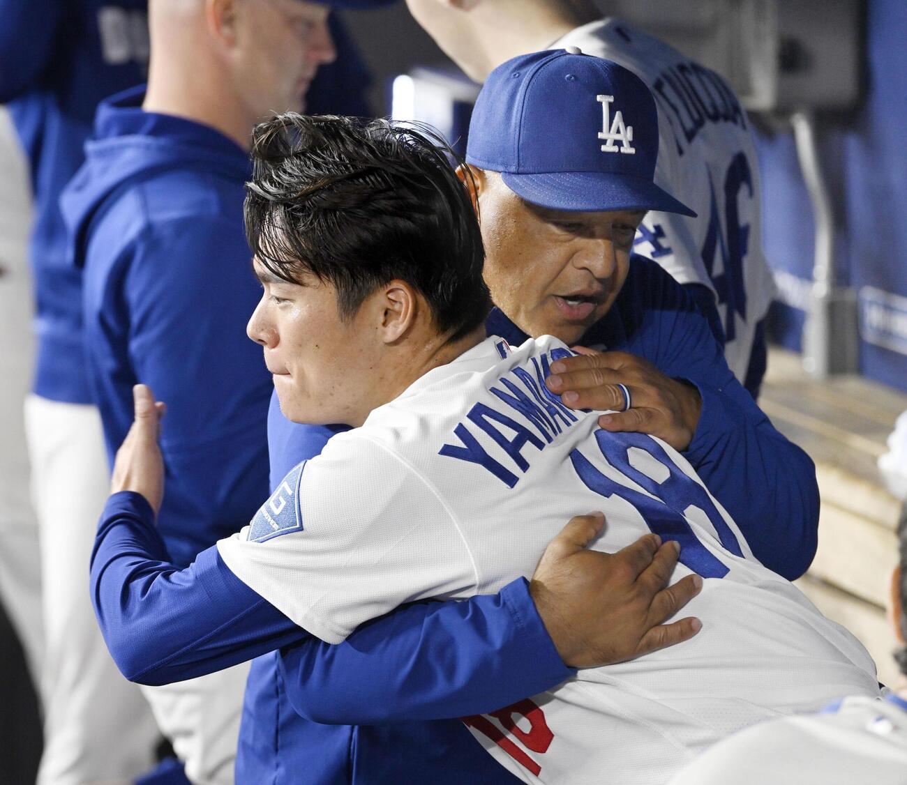 カージナルス戦の7回を投げ終え、ベンチでロバーツ監督（右）と抱き合うドジャース・山本＝ロサンゼルス（共同）