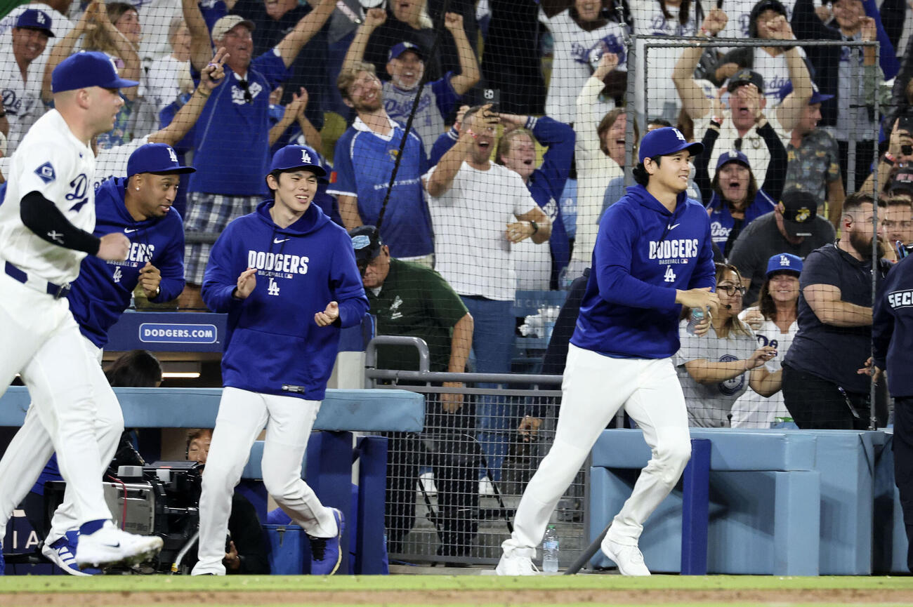 カージナルス戦の9回、チームがサヨナラ勝ちし、ベンチから駆け出すドジャースの（右から）大谷、佐々木朗ら（共同）