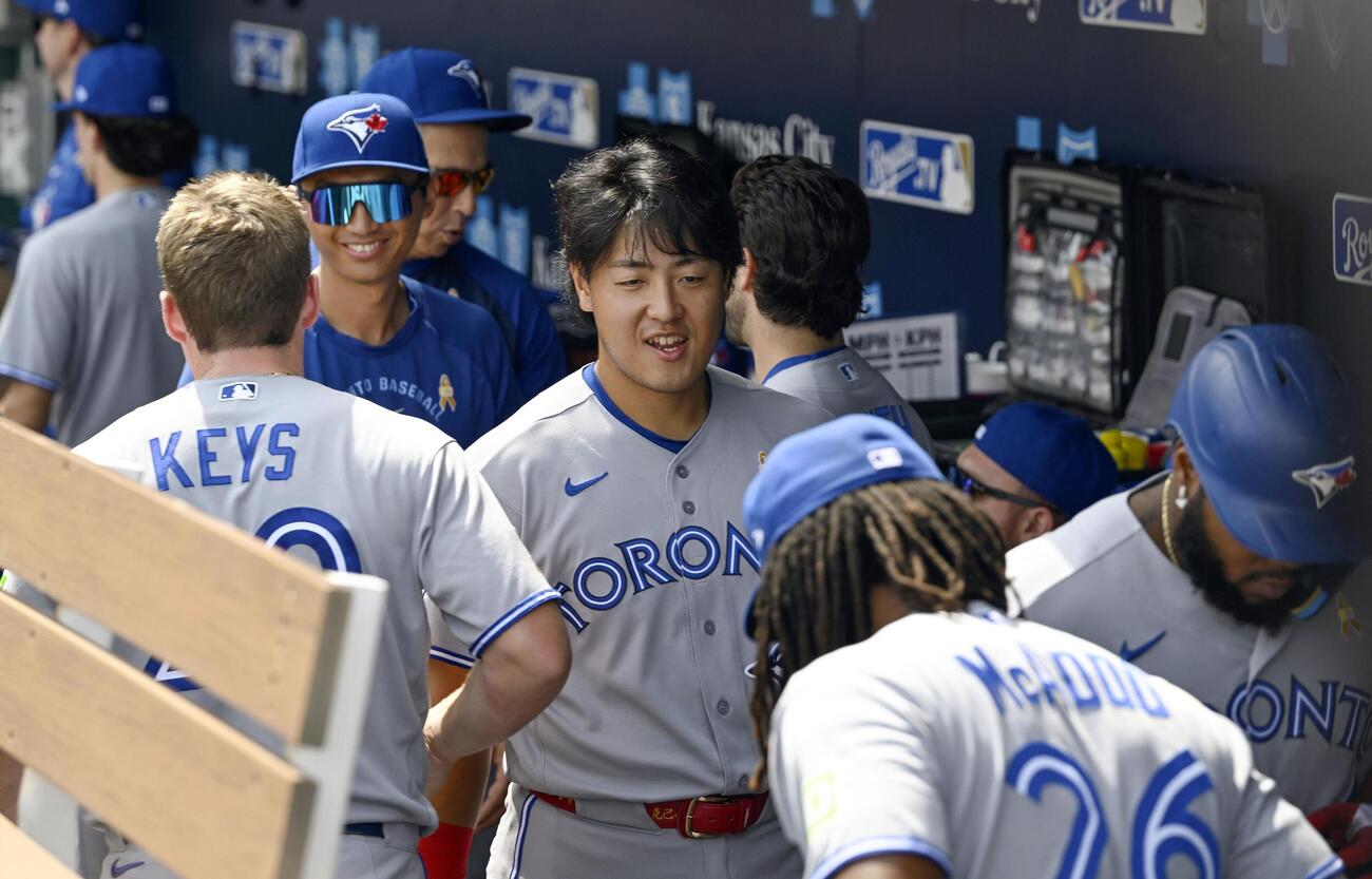 ロイヤルズ戦前にベンチで笑顔を見せるブルージェイズ・岡本＝カンザスシティー（共同）