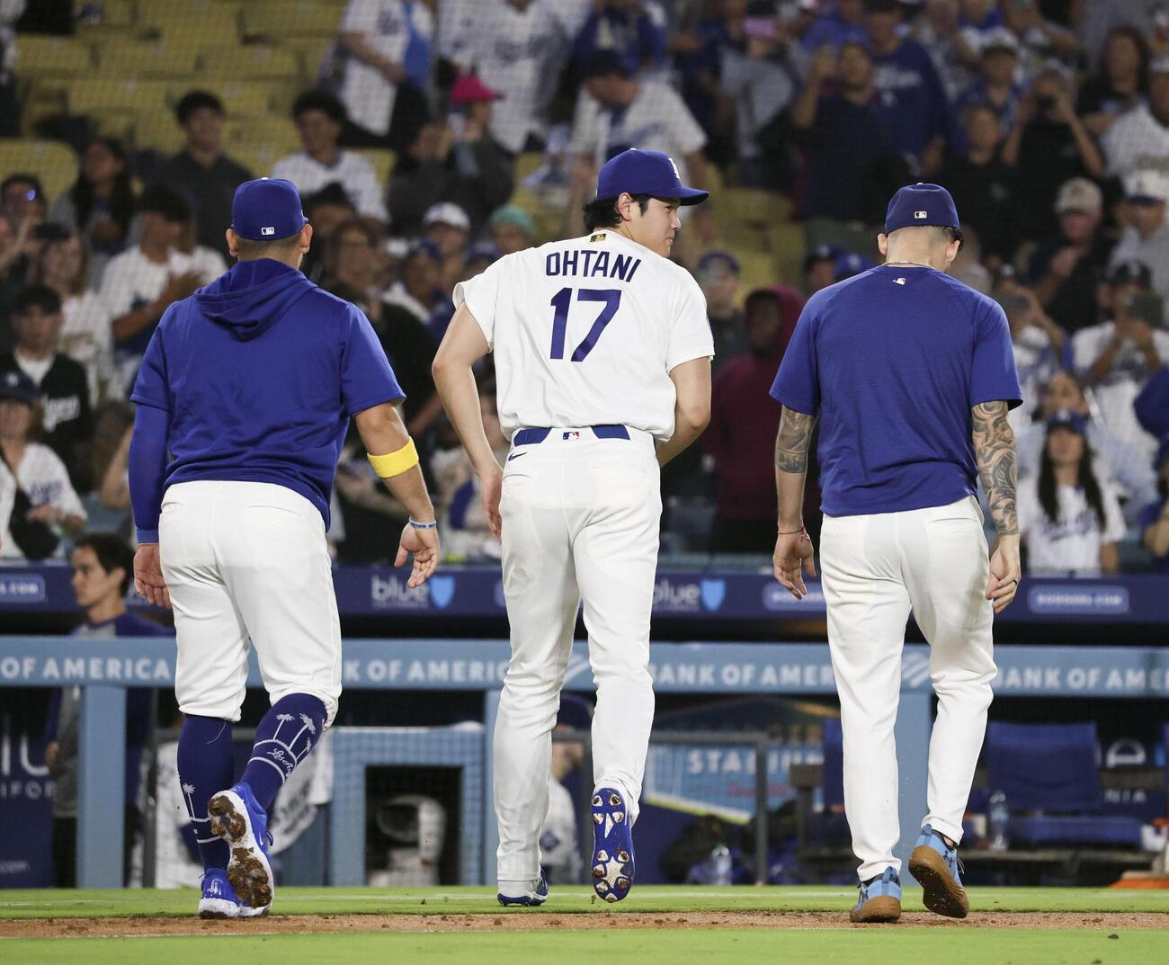 チームメートを迎えた後、ベンチに戻るドジャース・大谷（中央）＝ロサンゼルス（共同）