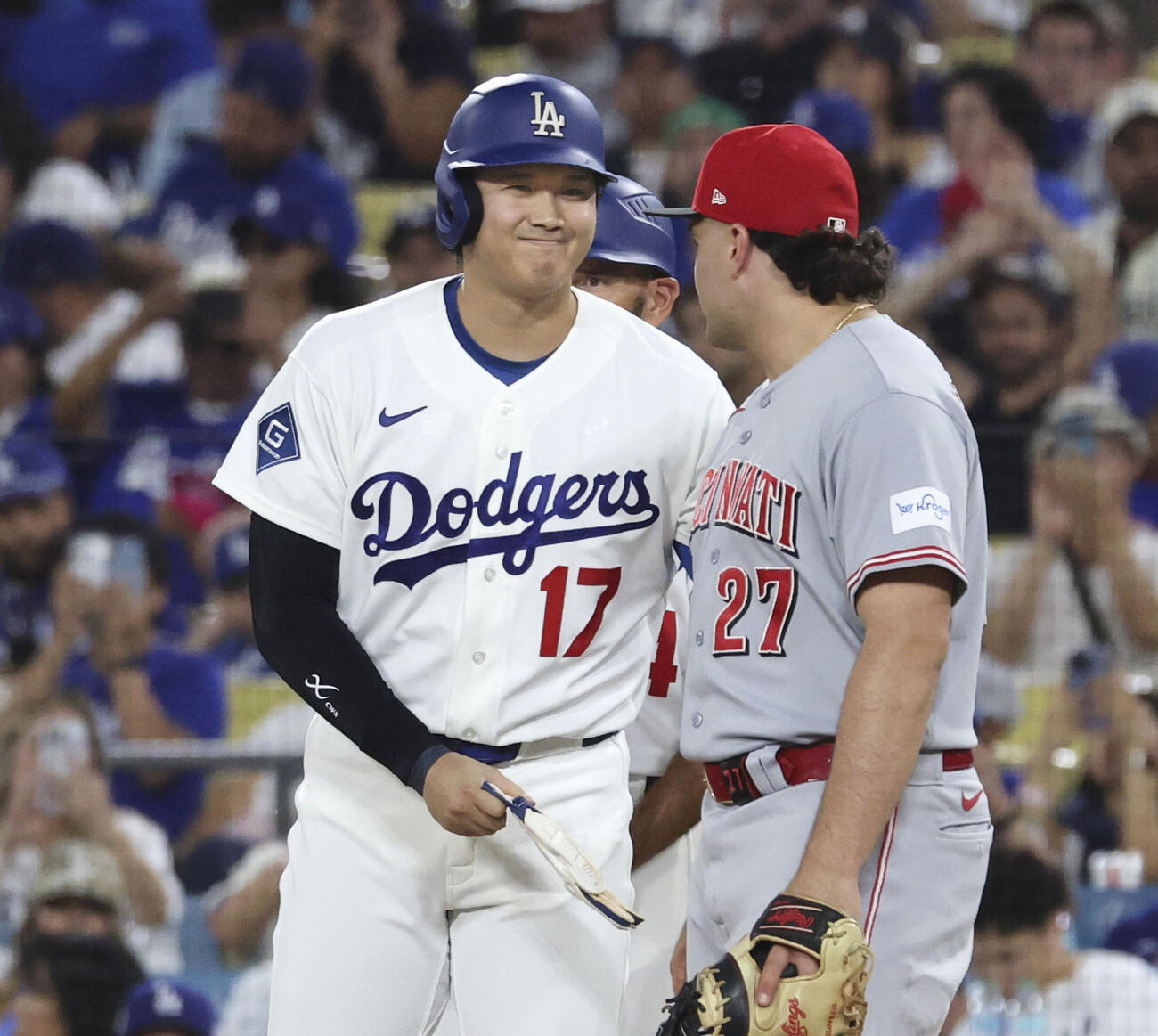 レッズ戦の7回、四球で出塁し、一塁手スチュワート（右）と笑顔で言葉を交わすドジャース・大谷＝ロサンゼルス（共同）