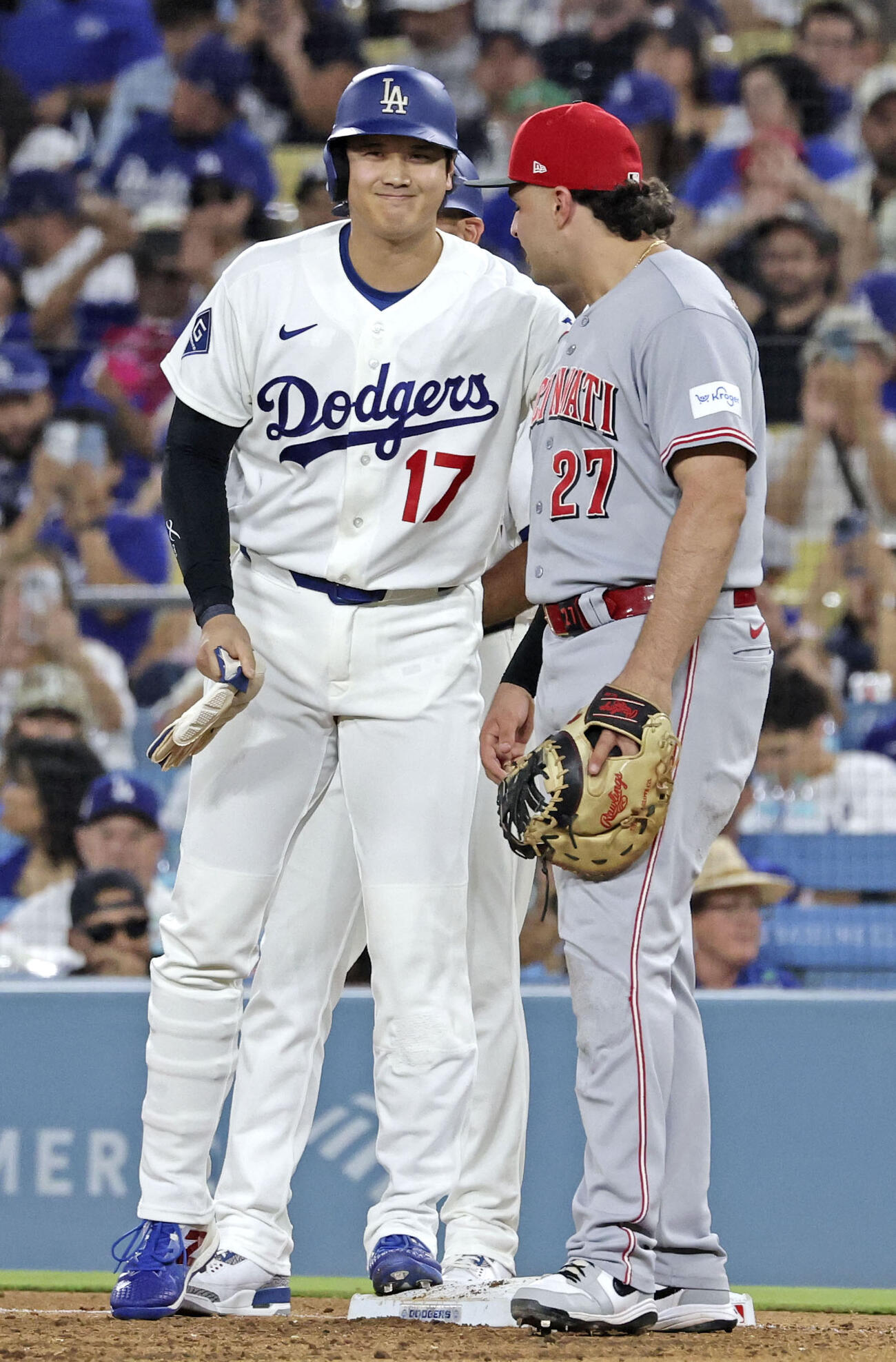 レッズ戦の7回、四球で出塁し、一塁手スチュワート（右）と笑顔で言葉を交わすドジャース・大谷＝ロサンゼルス（共同）