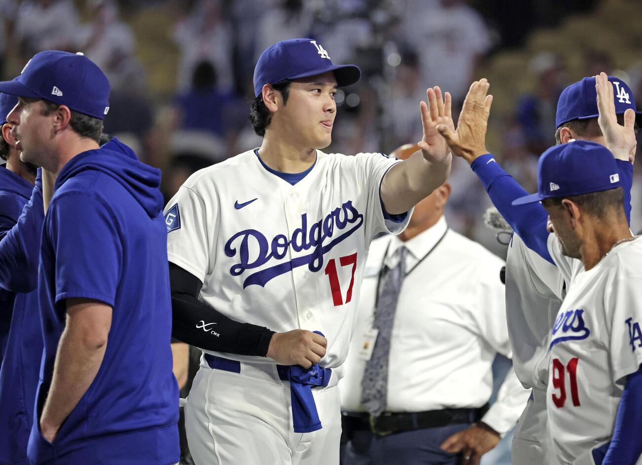 レッズに勝利し、チームメートとタッチを交わすドジャース・大谷＝ロサンゼルス（共同）