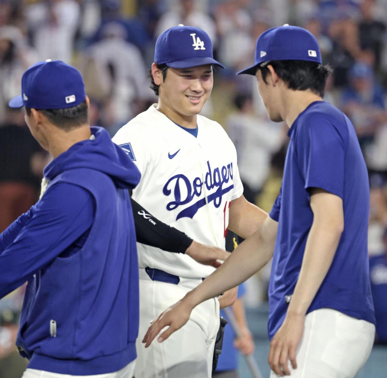レッズに勝利し、山本（左）、佐々木朗（右）とタッチを交わすドジャース・大谷＝ロサンゼルス（共同）