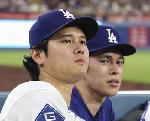 レッズ戦の9回、ベンチから試合を見るドジャース・大谷。右は佐々木朗=ロサンゼルス(共同)