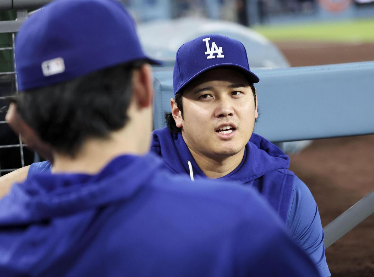 レッズ戦の1回、ベンチで佐々木朗（左）と話すドジャース・大谷（共同）