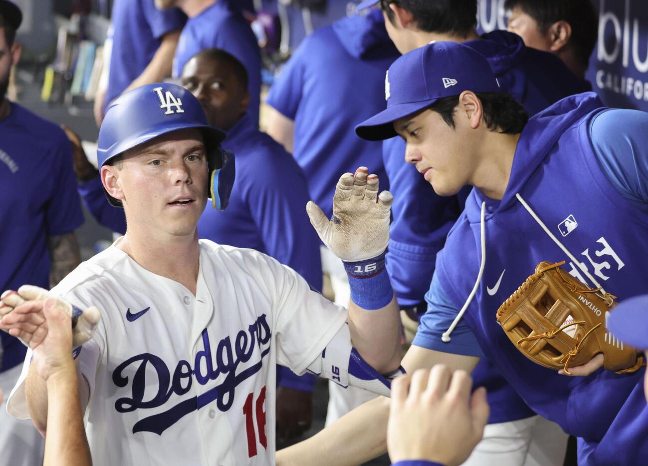 レッズ戦の1回、ソロ本塁打を放ったスミス（左）を迎えるドジャース・大谷＝ロサンゼルス（共同）