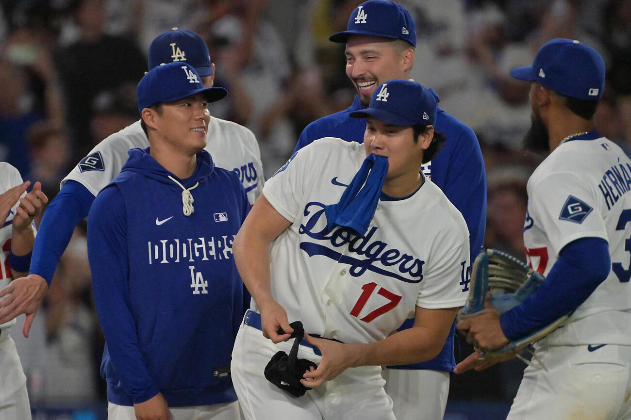レッズに勝利し、おどけた表情でナインを出迎えるドジャース大谷翔平（中央）。左は山本由伸（ロイター）