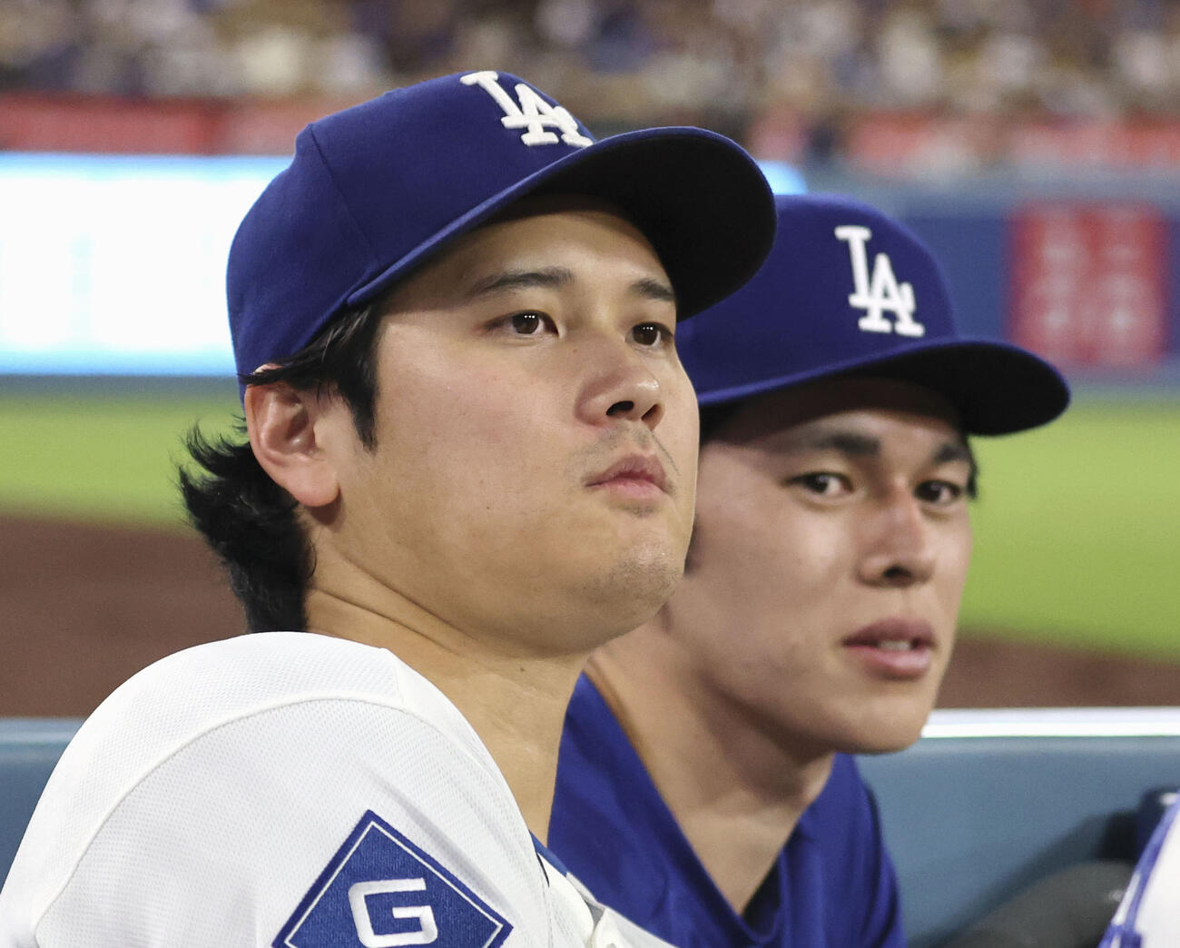 レッズ戦の9回、ベンチから試合を見るドジャース・大谷。右は佐々木朗＝ロサンゼルス（共同）