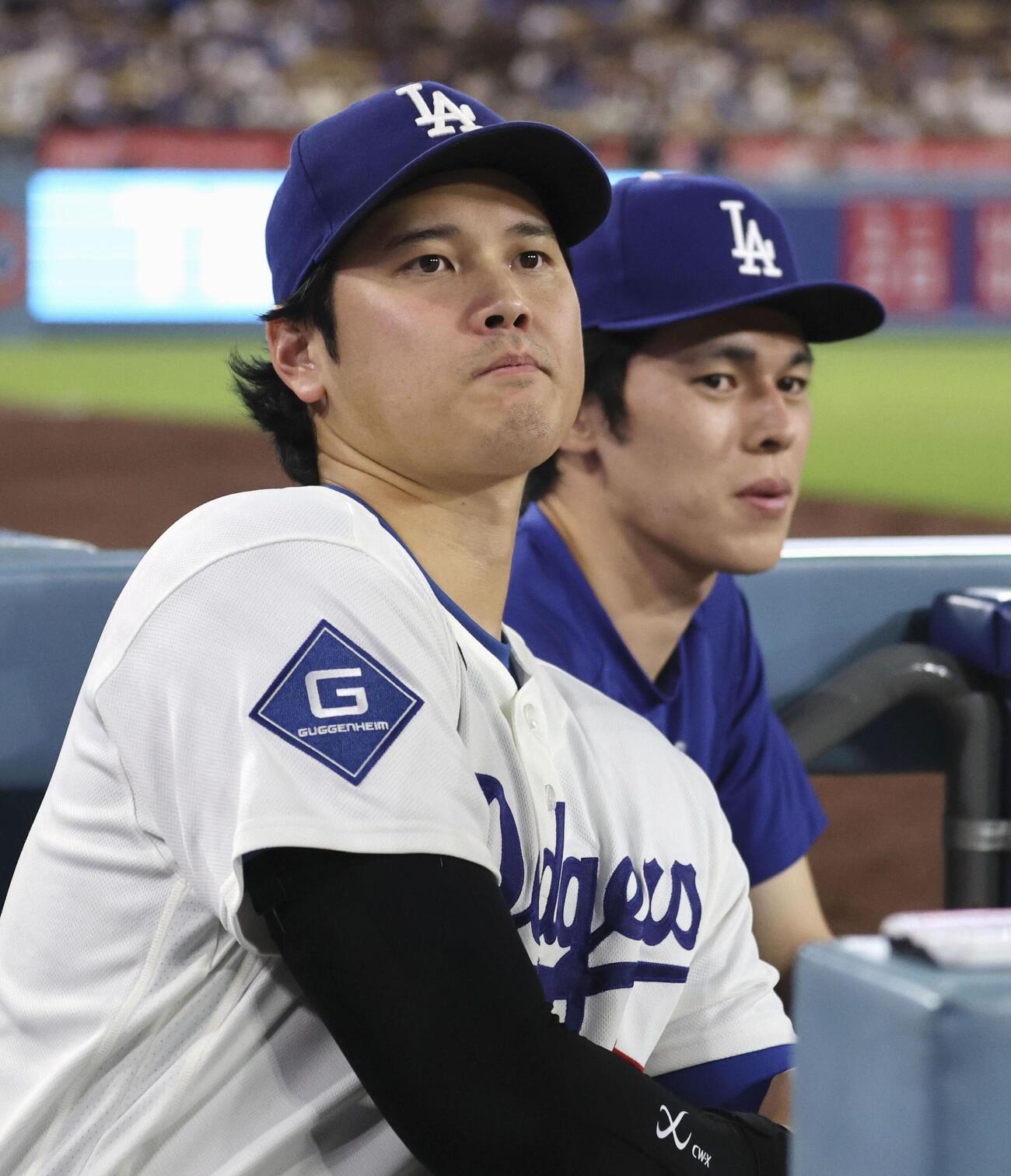 レッズ戦の9回、ベンチから試合を見るドジャース・大谷。右は佐々木朗＝ロサンゼルス（共同）