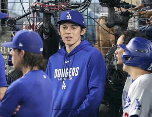 ジャイアンツ戦のベンチで話すドジャース・佐々木朗＝ロサンゼルス（共同）