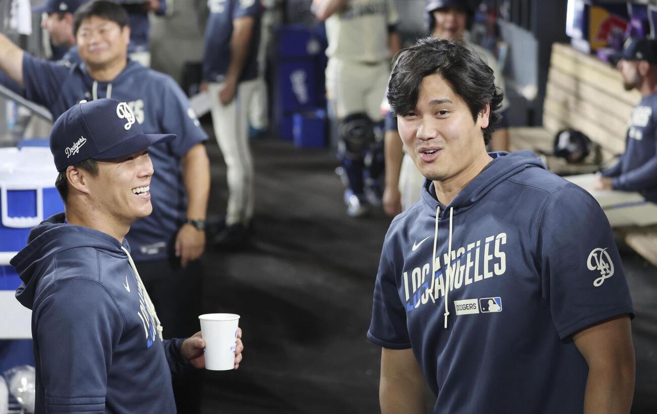 ジャイアンツ戦のベンチで話すドジャース・大谷（右）と山本＝ロサンゼルス（共同）