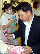 病院で子供にサインする井口（撮影・押谷謙爾）
