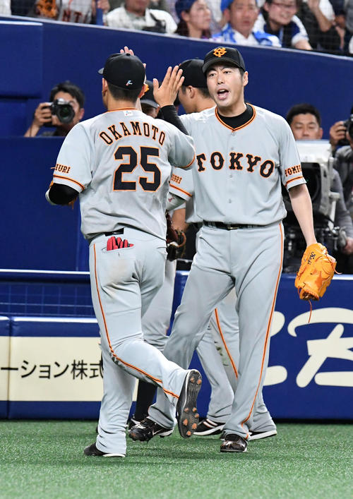 ８回、中日を無失点に抑えた上原（右）は岡本とタッチ（撮影・前岡正明）