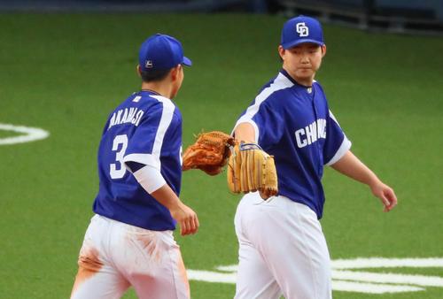 阪神対中日 6回裏阪神攻撃終了、小笠原(右)はピンチを乗り切り高橋周平とグラブタッチ(撮影・宮崎幸一)