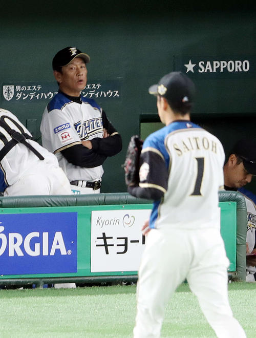 日本ハム対ロッテ　１回表を終え、引き揚げる斎藤（手前）を見つめる栗山監督（撮影・河野匠）