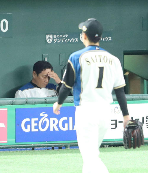 日本ハム対ロッテ　４回表ロッテ２死満塁、斎藤（手前）を降板させ、ベンチで頭を抱える栗山監督（撮影・河野匠）