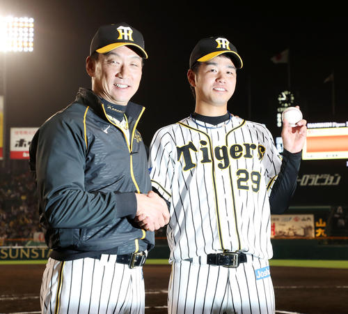 プロ初登板で初勝利を挙げた高橋遥人はウイニングボールを手に金本監督と握手する（撮影・加藤哉）