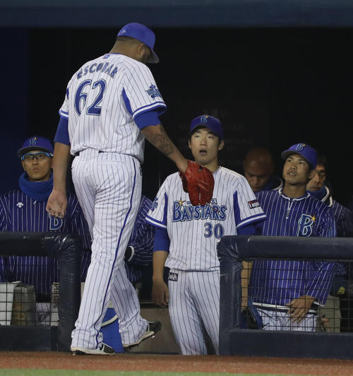 ＤｅＮＡ対巨人　６回表に逆転を許したエスコバーを出迎える飯塚（撮影・林敏行）