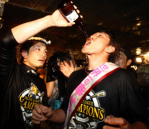 祝勝会で松田宣浩（左）からビールを飲まされる内川聖一