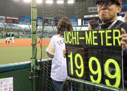 内川(左奥から2人目)の練習中、一塁側ベンチ横には「1999」のウチメーターのボードを持ったファンも登場(撮影・浅見桂子)