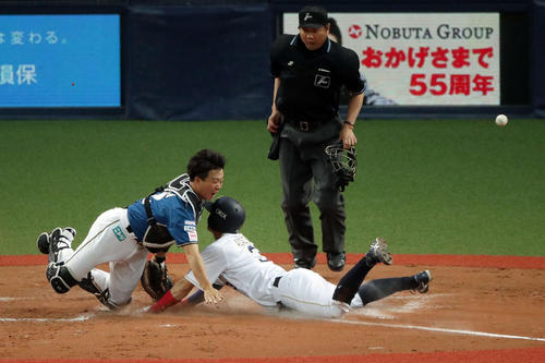 オリックス対日本ハム 12回裏オリックス2死満塁、捕手鶴岡(左)の失策でサヨナラの生還を果たす安達(撮影・前田充)
