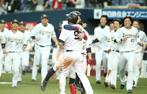 オリックス対日本ハム 12回裏オリックス2死満塁、日本ハム鶴岡慎也の悪送球で生還する安達はロメロと抱き合う(撮影・佐藤翔太)