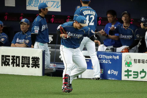 オリックス対日本ハム 1回裏、右翼の守備位置へ向かう際、すね当てを外し忘れあわててベンチへ戻る清宮(中央)(撮影・前田充)