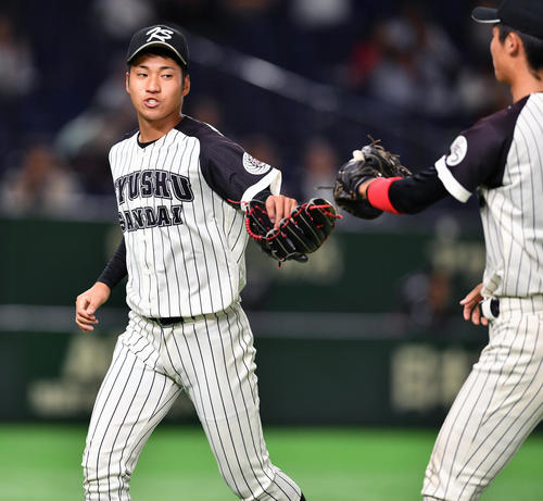 東海大対九産大　５回を抑えた九産大・岩田(左)は森一塁手とグラブタッチする（撮影・柴田隆二）