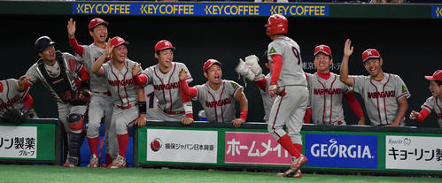 立命大対奈良学園大　１回裏奈良学園大１死三塁、菅田の適時打で生還した米満（手前）はナインとタッチを交わす（撮影・滝沢徹郎）