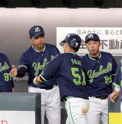 坂口の右前適時打で生還した藤井を出迎える小川監督(左奥)(撮影・佐藤翔太)