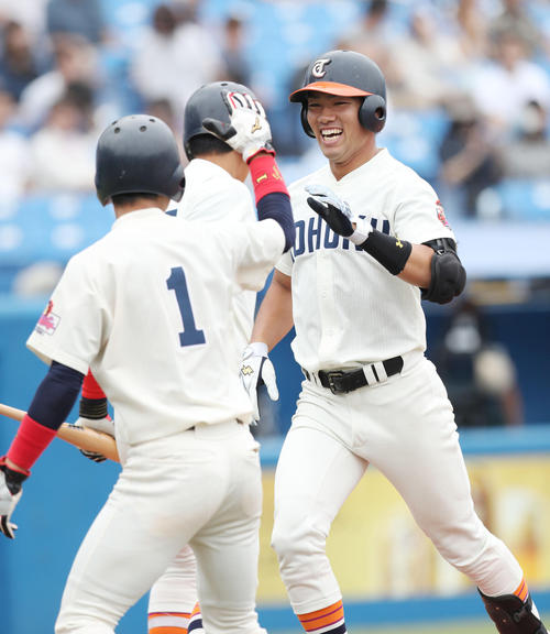国際武道大対東北福祉大 1回裏東北福祉大2死一塁、左越え本塁打を放った深江(右)は笑顔で生還し、元山とタッチを交わす(撮影・垰建太)