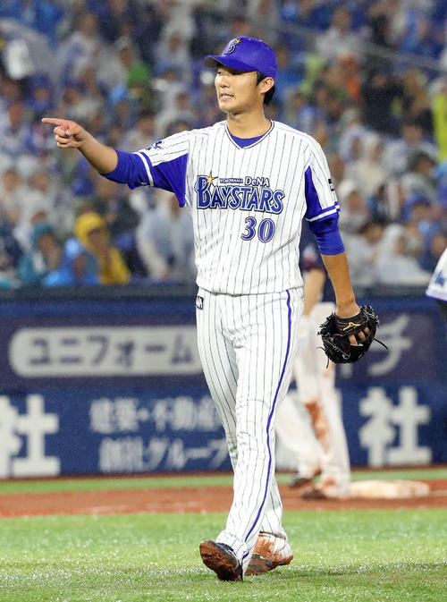 ５回表を１失点で切り抜け、好守の戸柱を指さす飯塚（撮影・河野匠）