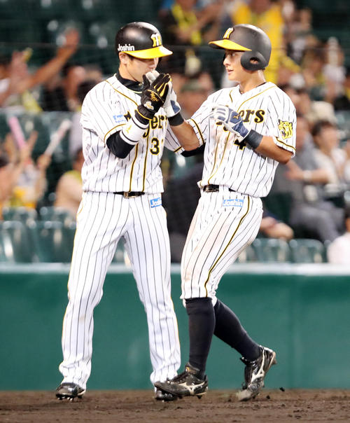阪神対オリックス 6回裏阪神2死二、三塁、熊谷(右)は糸井の右前適時打で生還する、左は三走山崎(撮影・加藤哉)
