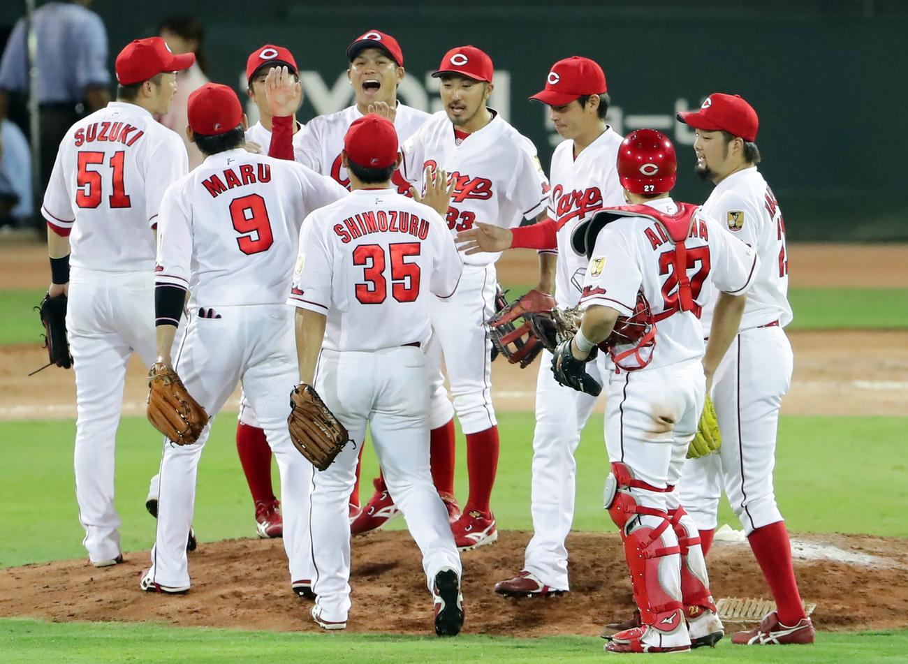 巨人に連勝し、笑顔でハイタッチする田中(中央)ら広島の選手たち(撮影・浅見桂子)