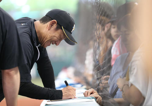 試合前、ファンにサインをする栗山監督（撮影・狩俣裕三）