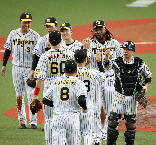 阪神対ヤクルト　９回表ヤクルト２死一塁、ドリスは川端を中飛に打ち取って勝利し、ナインとタッチする（撮影・加藤哉）