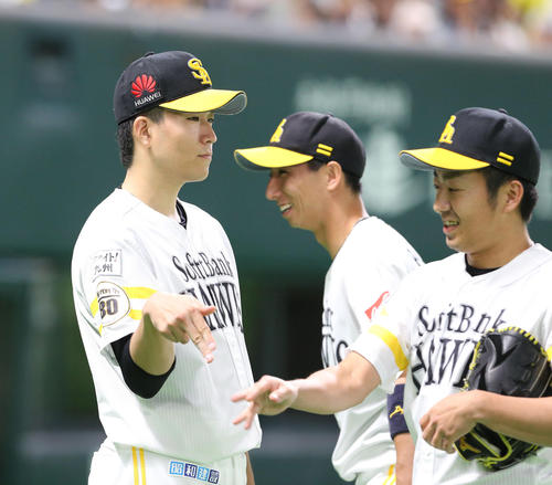 7回途中で降板した千賀滉大はきっちり抑えた嘉弥真新也（右）とハイタッチ（撮影・梅根麻紀）