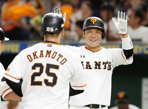 巨人対阪神　1回裏巨人2死二塁、二走坂本は岡本（左）の左翼越え2点本塁打で生還し笑顔を見せながらタッチで迎える（撮影・加藤哉）