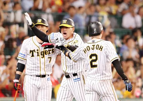 阪神対DeNA　5回裏阪神無死一、三塁、福留孝介は中越えに二塁打を放ち相手エラーの間に本塁生還を決め出迎えた糸井嘉男（左）、北條史也（右）と気合いの入った表情でタッチする（撮影・加藤哉）