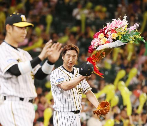 阪神対DeNA　7回表、阪神4番手で登板する藤川は700試合登板を達成し花束を受ける（撮影・加藤哉）