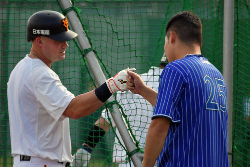 試合前練習で巨人マギー（左）とグータッチするDeNA筒香（撮影・滝沢徹郎）
