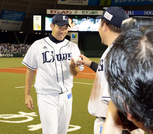 西武対ロッテ 11勝目を挙げた菊池は、笑顔で山川からウイニングボールを受け取る(撮影・浅見桂子)