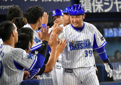 DeNA対ヤクルト　5回裏DeNA2死一、三塁、右越え3点本塁打を放った嶺井（手前右）はヘルメットを被らされてナインとハイタッチする（撮影・滝沢徹郎）