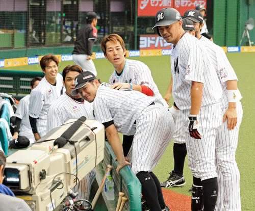 福浦和也（右手前）が右翼にソロ本塁打を放ち、TVカメラの前をスルーしたと思ったら、振り返って顔を決めるMLBのパフォーマンスを見せる＝2018年9月9日
